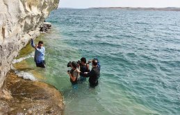 Kaya resimlerini görünce kıyafetleri ile suya daldılar