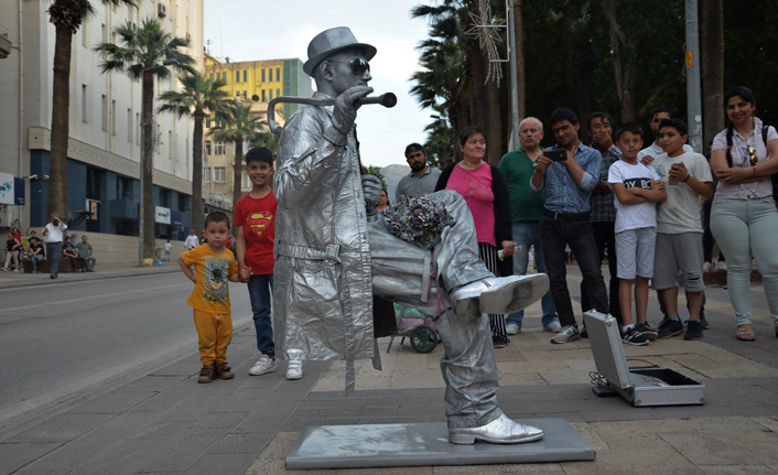 Tek ayağının üstünde oturan heykel adam görenleri şaşırttı