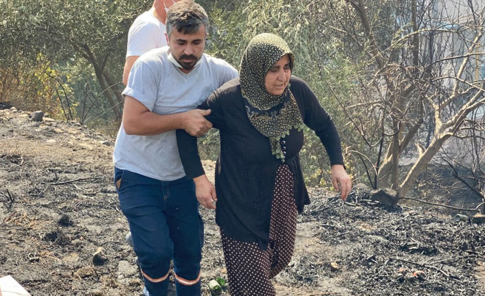 Yanan evine koşmaya çalışan kadını görevliler zor tuttu