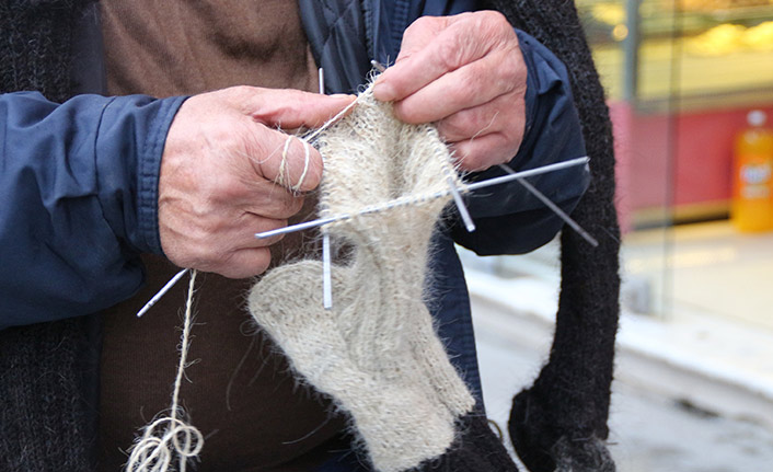 Sokak sokak gezip, ördüğü kıl çorapları satıyor
