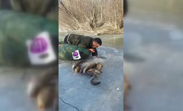 Buz altından elle balık çıkarıyor
