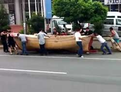 Evin çatısında kayık yapıyor