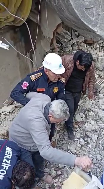 Enkazdan kurtardıkları yaşlı adama kendi botlarını giydirdi